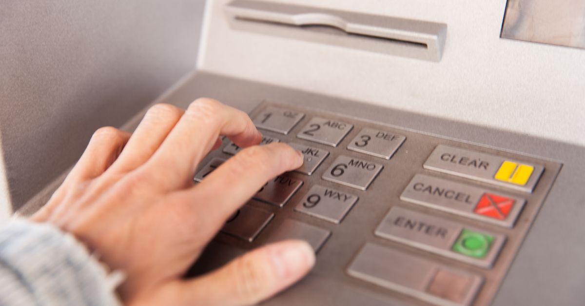 Hand using an outdated ATM keypad