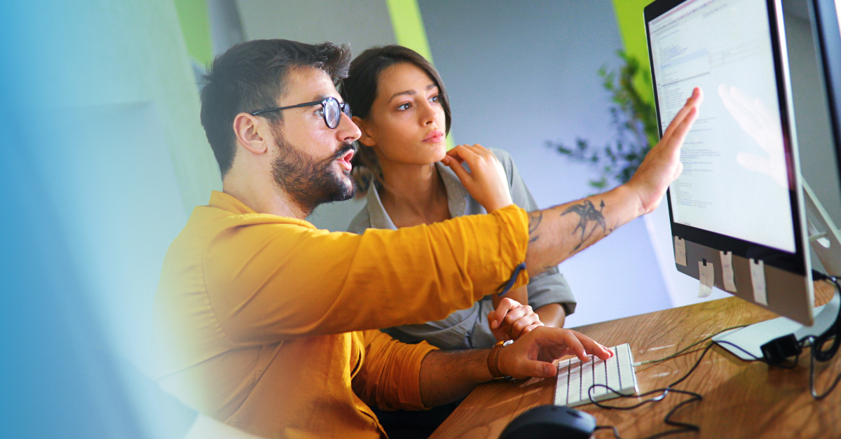 Man showing woman how to use software 