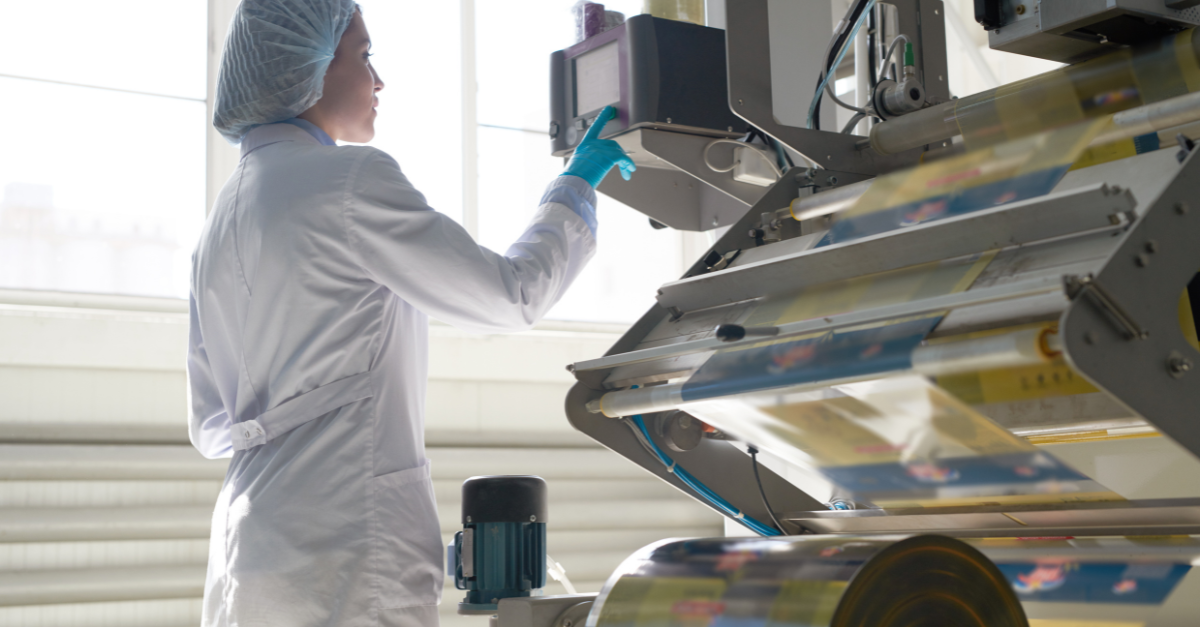 Woman wearing lab coat using industrial ink printing machine 