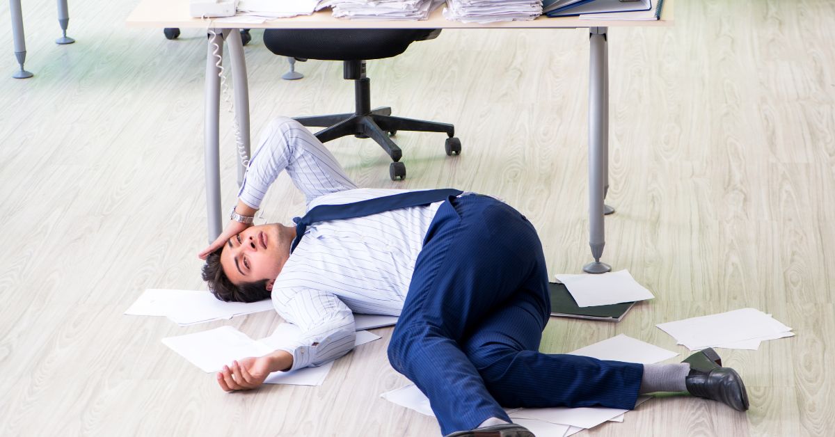 Overwhelmed man laying on floor of office